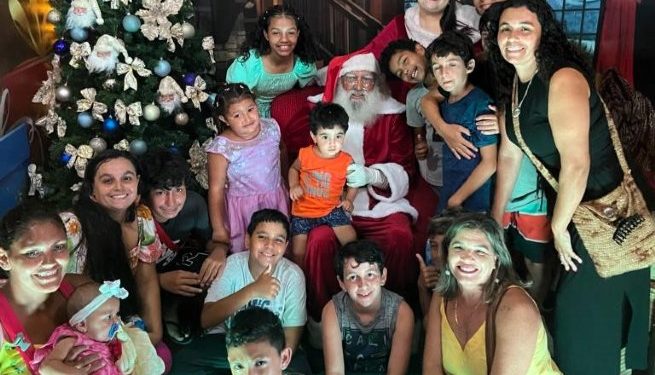 Alunos da Ilha do Montão de Trigo assistem a chegada do Papai Noel na Rua da Praia